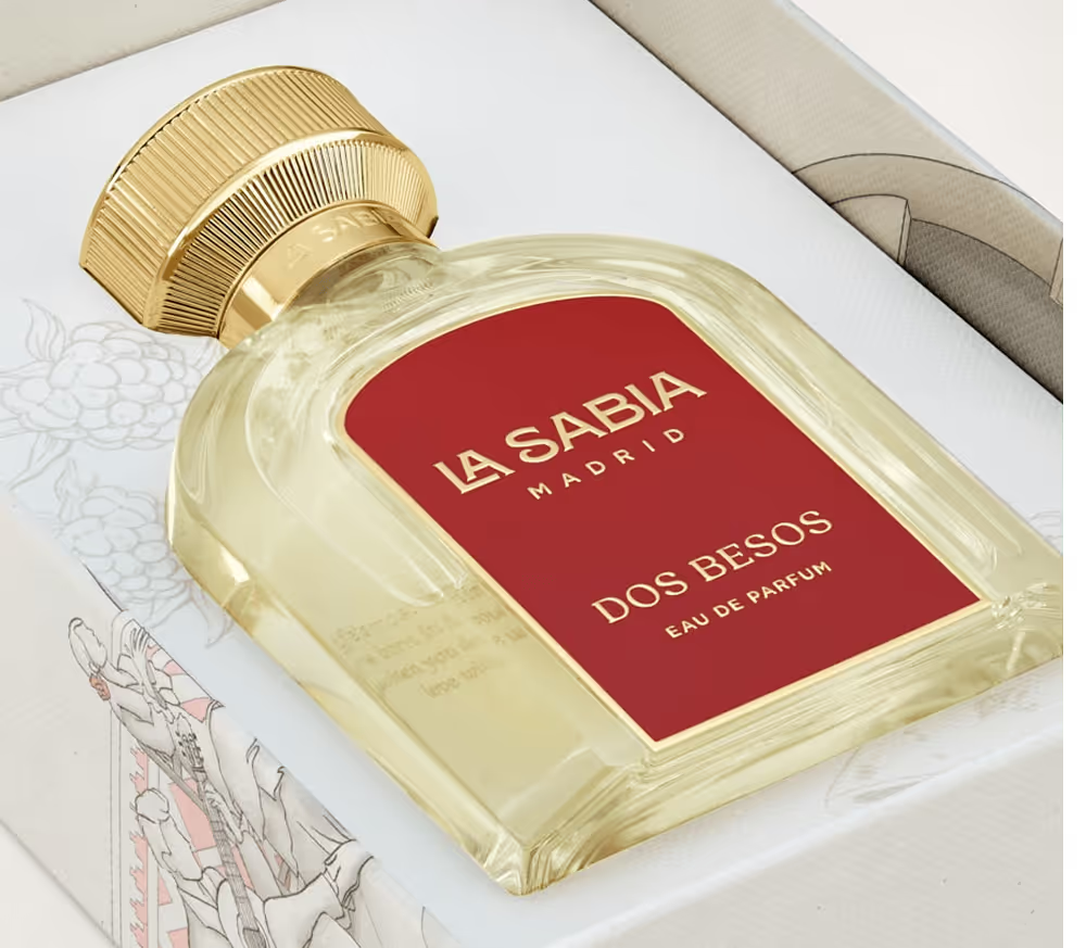 Perfume bottle labeled 'La Sabia Madrid Dos Besos' with gold cap on a white background